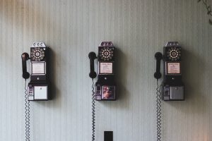 Couldn't find a picture of a three ring circus, so I improvised. This is a picture of 3 old-timey pay phones hanging on a grey-green striped wall. If you don't know what a pay phone is, ask an old person.