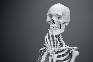 A skeleton in a pensive position contemplates the meaning of life and what to have for lunch